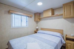 a small bedroom with a bed and a window at Bungalow F in Pontevedra +21 photos