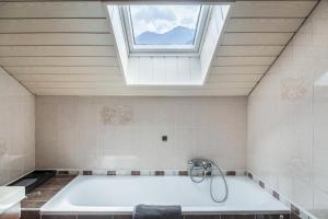 a bathroom with a bath tub with a skylight at Gletscherblick in Pusstratten +33 photos