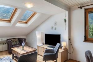 a living room with a television and a table and chairs at Gletscherblick in Pusstratten