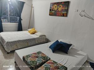 a bedroom with two beds and a picture on the wall at Villa ceiba in Guaduas