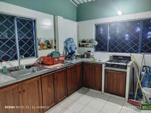 a kitchen with wooden cabinets and a stove top oven at Villa ceiba in Guaduas