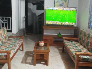 a living room with two couches and a flat screen tv at Villa ceiba in Guaduas