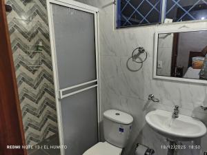 a bathroom with a shower and a toilet and a sink at Villa ceiba in Guaduas +3 photos