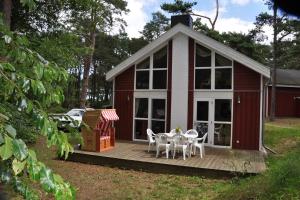 a house with a deck with a table and chairs at Ferienhaus Seebär in Baabe