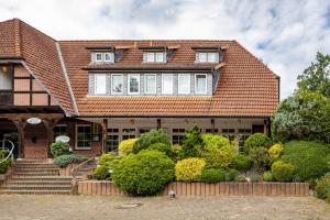 a brick house with a red roof and stairs at Haus Wacholder in Undeloh