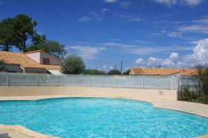 a large swimming pool in front of a fence at Maison La Vendéenne - Ref 508 in La Tranche-sur-Mer