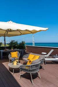 a deck with chairs and an umbrella and the ocean at Luxury terrazza in Bari
