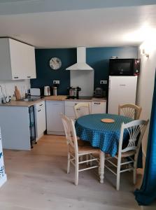 a kitchen with a table and chairs and a table and a table and a kitchen at Maison La Vendéenne - Ref 508 in La Tranche-sur-Mer +2 photos