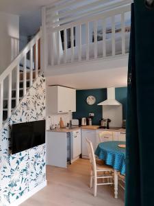 a kitchen and dining room with a table and a staircase at Maison La Vendéenne - Ref 508 in La Tranche-sur-Mer