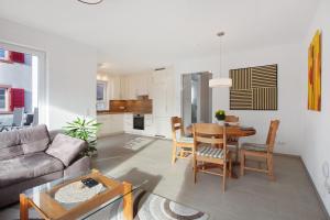 a living room with a couch and a table and chairs at Ferienwohnung am Klemmbach in Müllheim
