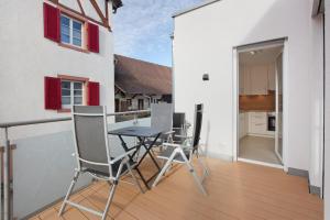 a patio with a table and chairs on a balcony at Ferienwohnung am Klemmbach in Müllheim