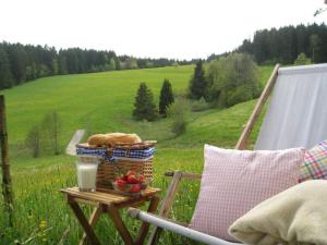a picnic table with a basket of food and a glass of milk at Klausenhof Schonach in Obertal +63 photos