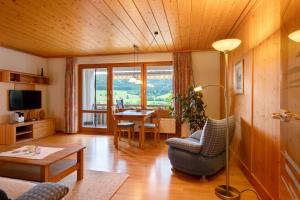 a living room with a table and a chair and a living room at Appartment Bergblick in Bernau im Schwarzwald