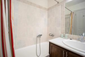 a bathroom with a bath tub and a sink at Almira in Livadi