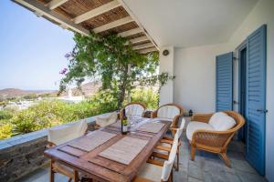 a wooden table and chairs on a patio at Almira in Livadi