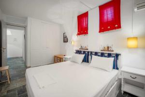 a bedroom with a white bed and red cabinets at Almira in Livadi