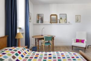a bedroom with a bed and a table and chairs at Quartier De La Madeleine in Angers