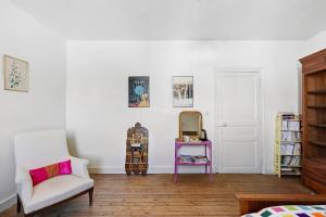 a room with a chair a mirror and a table at Quartier De La Madeleine in Angers