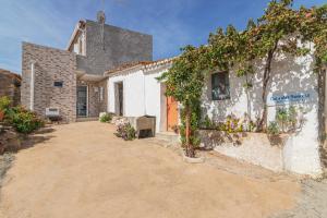 a white house with plants on the side of it at Casa das Bonecas in Farelos de Baixo