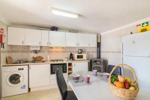 a kitchen with a table with a basket of fruit on it at Casa das Bonecas in Farelos de Baixo