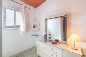 a bedroom with a dresser with a mirror and a window at Casa das Bonecas in Farelos de Baixo +24 photos
