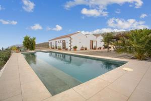 a swimming pool in front of a house at Casa del Cielo in Adeje