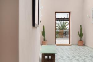a hallway with a green bench and cactus at Casa del Cielo in Adeje