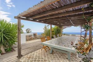 a patio with a table and chairs under a pergola at Casa del Cielo in Adeje