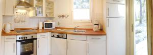 a kitchen with a white refrigerator and a sink at Ferienhaus 254 Strandpark Baabe in Baabe +5 photos