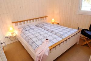 a bedroom with a bed with a pink blanket on it at Ferienhaus 254 Strandpark Baabe in Baabe