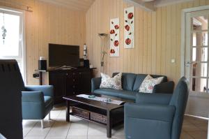 a living room with a blue couch and a coffee table at Ferienhaus 254 Strandpark Baabe in Baabe