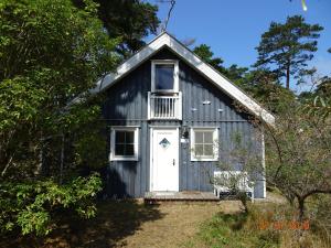 a blue barn with a white door and windows at Ferienhaus 254 Strandpark Baabe in Baabe