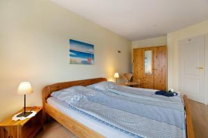 a bedroom with a bed with a blue comforter at Ferienwohnung Postel in Meldorf