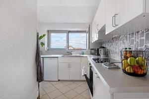 a kitchen with white cabinets and a bowl of fruit on the counter at Haus Castellbergblick Dachgeschoss in Ballrechten