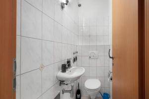 a white bathroom with a sink and a toilet at Haus Castellbergblick Dachgeschoss in Ballrechten +13 photos