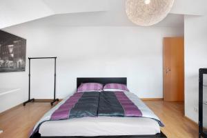 a bedroom with a large bed with purple pillows at Haus Castellbergblick Dachgeschoss in Ballrechten
