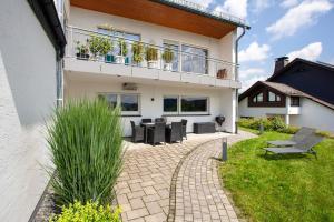 a house with a patio with a table and chairs at Ferienwohnung Am Wald in Eslohe