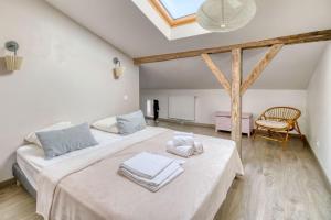 a white room with two beds and a chair at Villa Virginie gite 1 in Faudoas +25 photos
