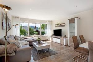 a living room with a couch and a tv at Ferienwohnung Am Wald in Eslohe