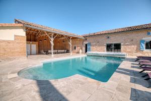 a swimming pool in front of a building at Villa Virginie gite 1 in Faudoas