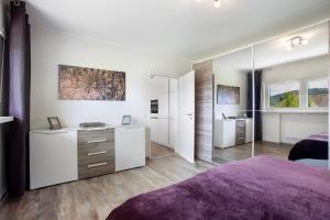 a bedroom with white walls and a purple bed at Ferienwohnung Am Wald in Eslohe