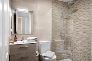 a bathroom with a shower and a toilet and a sink at Apartamento White Sun in Playa Honda +12 photos
