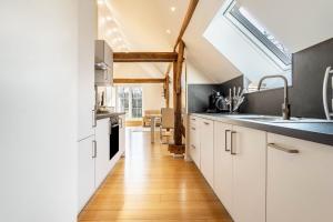 a kitchen with white cabinets and a large window at Pendler- und Ferienwohnung Bröke in Ahaus
