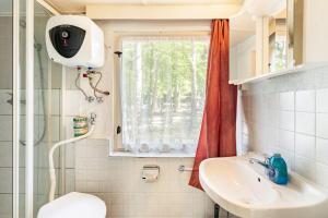 a bathroom with a toilet and a sink and a window at Bungalow 6 - Finnhütte in Niesky +10 photos