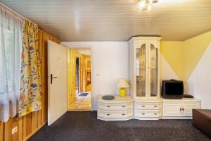 a room with a tv and a dresser with a tv at Bungalow 6 - Finnhütte in Niesky