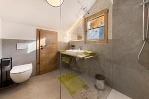 a bathroom with a toilet and a sink and a shower at Apartments Schlernheim in Fie allo Sciliar +72 photos