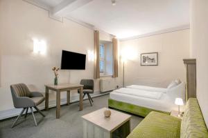 a hotel room with a bed and a couch at Luckau Appartements 1695 in Luckau