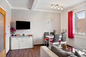 a living room with a table and a tv at Ferienwohnung Thüringer Wald in Ilmenau