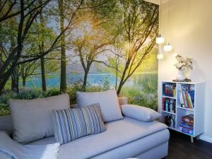 a living room with a couch and a painting of trees at Am Froschteich in Dolgen