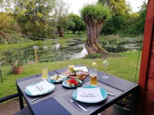 a table with two plates of food and glasses of wine at Am Froschteich in Dolgen